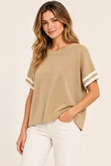 Remera tejida de punto color camel con cuello redondo y mangas cortas holgadas que presentan franjas blancas en los puños.