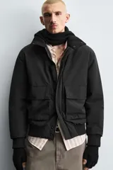 Cazadora de corte regular fit confeccionada en tejido técnico repelente al agua y resistente al viento. Presenta cuello subido, cierre frontal con cremallera oculta por solapa, bolsillos de plastrón con solapa en la parte frontal y acabados en rib en puños y cintura. Cuenta con relleno térmico transpirable.