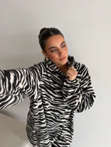 Canguro de viscosa con estampado animal print de cebra, cuello alto y mangas largas con puños elásticos.
