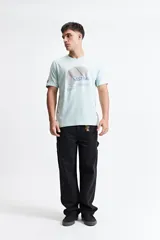 Remera de manga corta color menta, con estampado frontal de un diseño abstracto en tonos grises y azules, y texto. Confeccionada en 100% algodón y de corte regular.