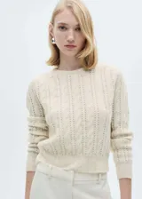 Jersey de punto grueso con diseño trenzado y calado, cuello redondo y terminaciones de canalé en puños y ruedo.