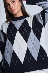 Sweater de punto con diseño de rombos en tonos negro, gris y blanco. Cuello redondo y corte clásico.
