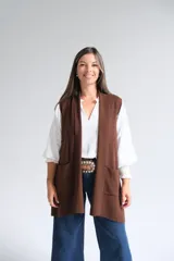 Chaleco largo abierto de tejido de punto color chocolate, con bolsillos frontales aplicados y diseño sin mangas.