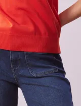 Musculosa tejida color naranja, de hilado fino y cuello redondo.