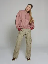 Pantalón cargo color beige, de corte recto y tiro alto, con bolsillos laterales con solapa y bolsillos traseros.