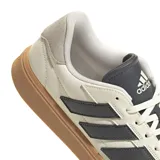 Championes Adidas Court Block color crema con detalles en gris oscuro y suela marrón. Presentan las tres tiras características de la marca en los laterales.