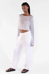 Sweater crop plateado de manga larga, tejido con hilo brillante con lurex, escote bote amplio y diseño relajado.