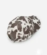 Gorra de sarga con estampado animal print de vaca, modelo dad hat con visera curva y ajuste trasero. Confeccionada en algodón sostenible.