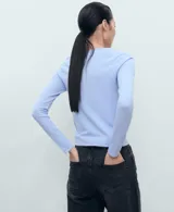 Jersey de punto fino color celeste con cuello redondo y diseño entallado de manga larga.