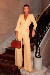 Blazer amarillo con solapas, corte entallado, cierre cruzado con botón y cinturón con hebilla redonda.