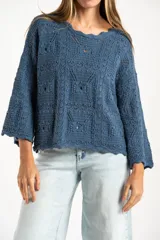 Sweater de tejido de punto calado color marrón, con diseño oversize, cuello redondo y mangas tres cuartos.