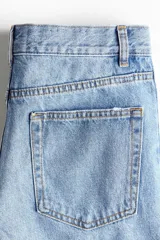 Jeans de corte barrel en denim de algodón, de tiro medio y diseño holgado con piernas curvas. Presenta diseño de cinco bolsillos, trabillas para cinto y cierre frontal con botón y cremallera.