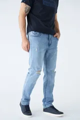 Jean de corte recto en color azul claro, con diseño de tiro medio y cintura regular. Presenta detalles de roturas en las rodillas y logo bordado en el bolsillo pequeño delantero.