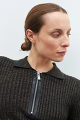 Sweater verde oliva de tejido de punto acanalado, con cuello polo, cierre metálico frontal y mangas largas.