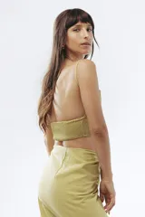 Crop top de lino color verde oliva, con escote halter y detalle de fruncido en la parte inferior.