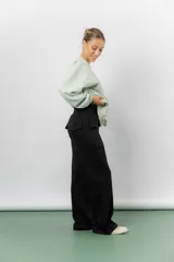 Pantalón blanco de silueta amplia y caída fluida, con cintura alta elastizada y lazo regulable con terminaciones metálicas.