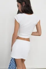 Falda corta gris melange de tiro medio con cintura elástica, confeccionada en hilatura con mezcla de algodón. Cuenta con forro interior tipo shorts del mismo tejido.