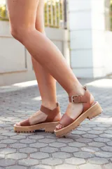 Sandalias de cuero color tostado con plataforma track y hebilla metálica.