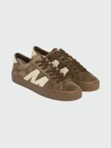 Zapatillas Moncler modelo Moncado2, confeccionadas en gamuza color marrón con detalle de letra M en cuero color crema en los laterales. Presentan cordones al tono y suela de goma color marrón.
