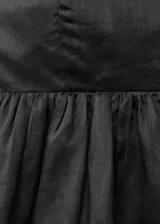 Top strapless de corte estilo globo con bajo abullonado, confeccionado en tejido de ramio con forro de viscosa y cierre de cremallera en la parte posterior.