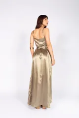 Vestido largo dorado satinado, de corte cruzado con escote en V, mangas finas y lazo en la cintura.