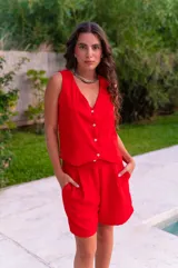 Bermuda color rojo de crepé, con pliegues frontales, bolsillos laterales y corte holgado.