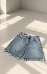 Bermuda de jean de tiro alto con lavado clásico y bordes desflecados.