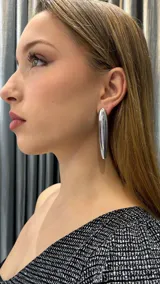 Aros colgantes plateados con forma de lágrima alargada.