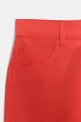 Falda midi de tiro medio en color rojo, con trabillas, cinco bolsillos, abertura delantera y cierre con cremallera, botón interior y gancho metálico. Colección especial Fruit of the Loom x Zara.