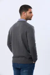 Buzo de lana azul con cuello redondo, manga larga y diseño tejido de punto.