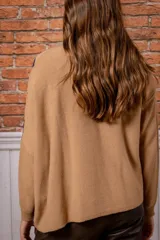 Sweater de punto con diseño de rombos en colores beige y azul marino, cuello redondo y mangas largas.