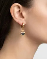 Caravanas tipo argolla con dije colgante en forma de oso con corazón negro central, confeccionadas en acero dorado.