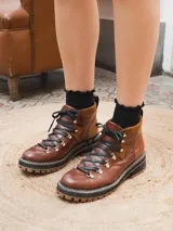 Borcego de cuero negro con cordones y suela track color caramelo.