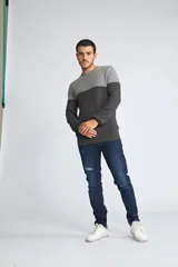 Sweater de punto con diseño color block en tonos gris claro y gris oscuro, de cuello redondo y manga larga. Presenta un pequeño logo bordado en el pecho.