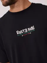 Remera blanca de algodón con estampado en la espalda que incluye un sol con un surfista en el centro, texto y motivos playeros.