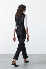 Chaleco de estilo utilitario color bordó con pespuntes blancos a contratono. Presenta solapas, cierre frontal con botones, bolsillos delanteros y un diseño estructurado.