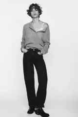 Jeans de tiro alto color negro con efecto lavado, corte mom fit, cinco bolsillos y cierre frontal con cremallera y botón metálico.