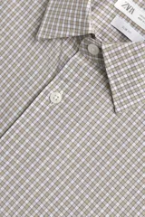 Camisa de corte slim fit confeccionada en tejido de algodón, con estampado de cuadros pequeños en tonos beige y blanco. Presenta cuello italiano, manga larga con puños abotonados y cierre frontal con botones.