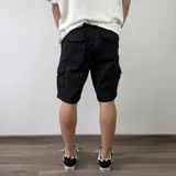 Bermuda cargo de gabardina color gris oscuro, con múltiples bolsillos laterales con solapa y cierre de botones.