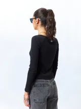 Remera blanca de algodón, de manga larga y cuello redondo.