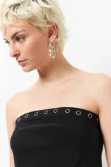 Top strapless tipo corset de color negro, con diseño estructurado y detalle de ojalillos metálicos en el borde superior.