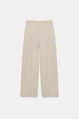 Pantalón de tiro medio color beige, con pinzas delanteras, bolsillos frontales y pernera recta. Cuenta con cierre frontal con cremallera, botón interior y gancho.