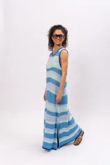 Vestido largo de algodón tejido a rayas horizontales en tonos celeste, azul y verde agua. Diseño holgado con cuello redondo y aberturas laterales en el ruedo.