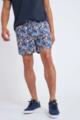Short de baño con cintura elástica y cordón ajustable, confeccionado en tela ligera de secado rápido. Presenta un estampado botánico integral en tonos amarillos, blancos y azules, con dos bolsillos delanteros y uno posterior.