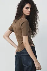 Camiseta de algodón color terracota con efecto lavado, cuello redondo y manga corta. Posee un bajo redondeado.