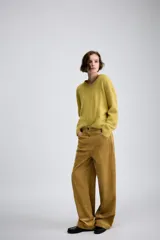 Pantalón de tiro medio confeccionado en tejido de pana, con diseño de pierna ancha, bolsillos delanteros y traseros, y cierre frontal con cremallera y botón.