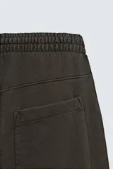 Pantalón cargo de corte relajado con efecto lavado, confeccionado en tejido de algodón. Presenta cintura elástica, bolsillos laterales de plastrón con solapa y bolsillos delanteros.