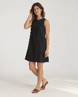 Vestido corto sin mangas de silueta evasé y calce relajado, color negro, con escote redondo, terminación ancha en el ruedo y abertura en la espalda con lazo.