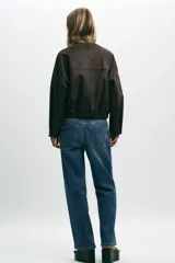 Campera bomber color beige, de cuello redondo y manga larga. Tiene bolsillos delanteros y bajo acabado en elástico. Cierre frontal con cremallera.