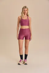 Top deportivo negro con tirantes finos cruzados en la espalda y relleno extraíble. Fabricado en tejido Allure® con tecnología LYCRA® ADAPTIV, ofrece elasticidad, adaptándose al cuerpo y realzando la figura.